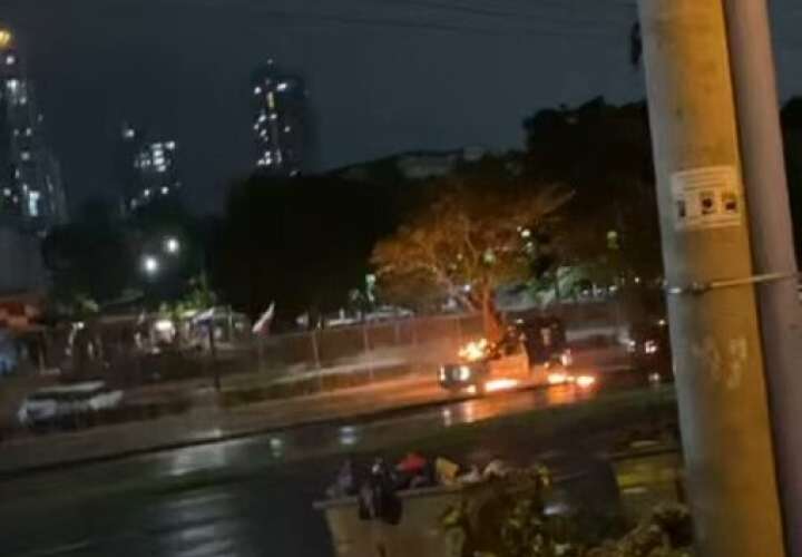 Patrulla policial incendiada durante la protesta nocturna.