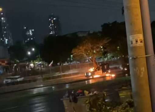 Patrulla policial incendiada durante la protesta nocturna.