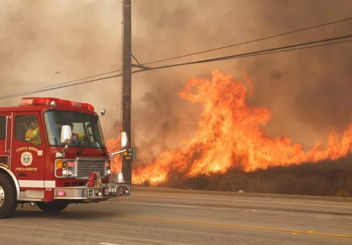 Un camión de bombero pasa frente a un incendio el de octubre de 2017, en Anaheim Hills, California (EE.UU.). EFE