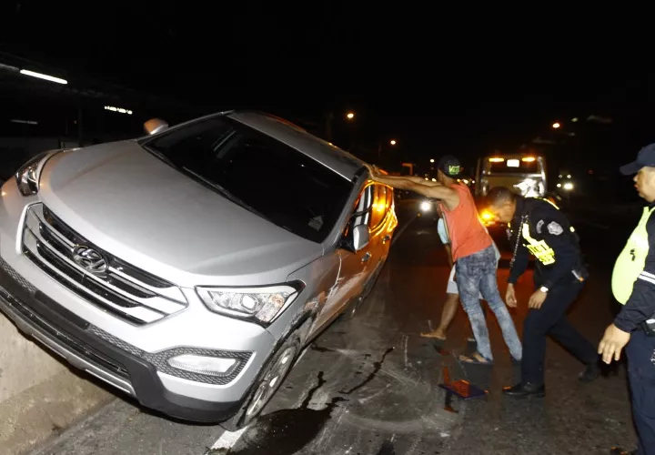 Entre conductores, policías y otros enderezaron el auto mientras llegaba la ambulancia. Fotos Alexander Santamaría Crítica