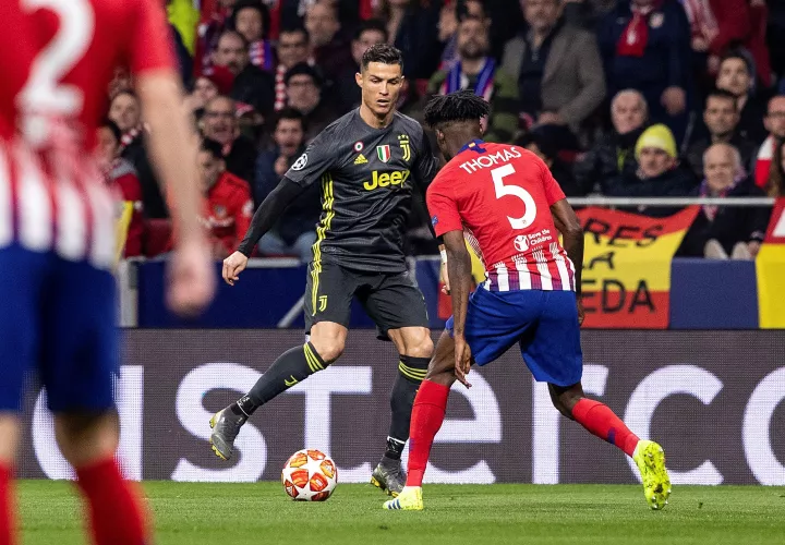  Cristiano Ronaldo (i) pelea un balón con el centrocampista ghanés del Atlético de Madrid Thomas Partey durante el partido de ida de octavos de final de la Liga de Campeones. /EFE