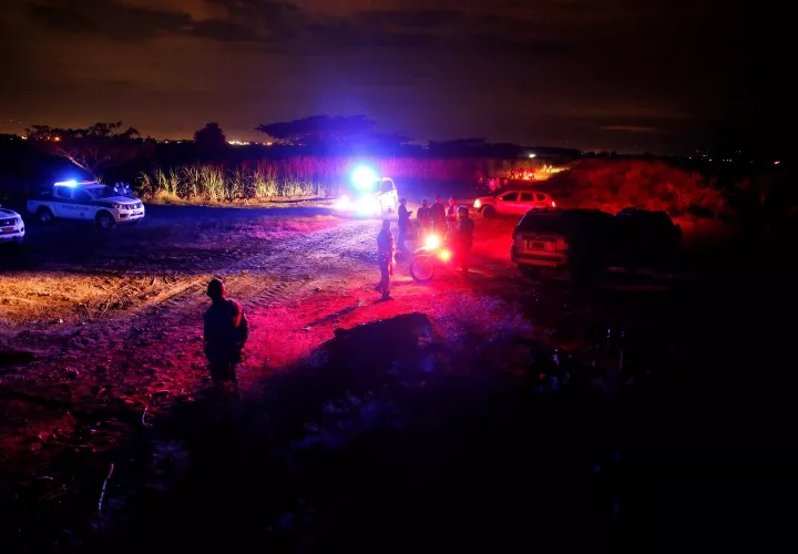 Policías prestan seguridad en el lugar donde asesinaron a cinco jóvenes.  FOTO/EFE