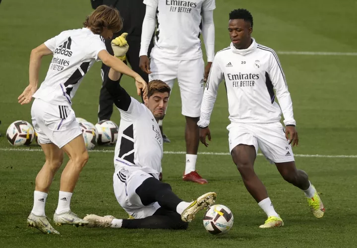 Thibaut Courtois (c) arrebata el balón al centrocampista croata Luka Modric (i) y al delantero brasileño Vinicius Jr durante un rondo del entrenamiento. Foto: EFE