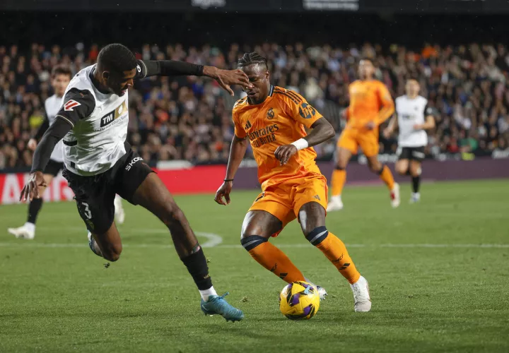 Vinicius Jr. (d) lucha con Cristhian Mosquera (i), del Valencia. /Foto: EFE